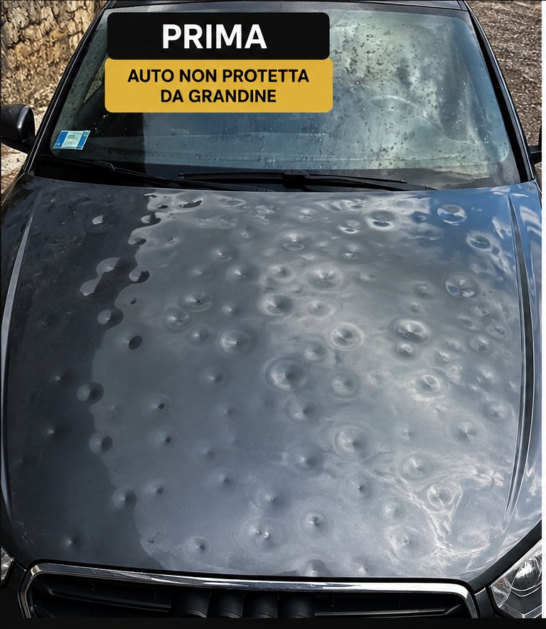 Cofano di un'auto grigia non protetta, coperto di bolli dopo una grandinata