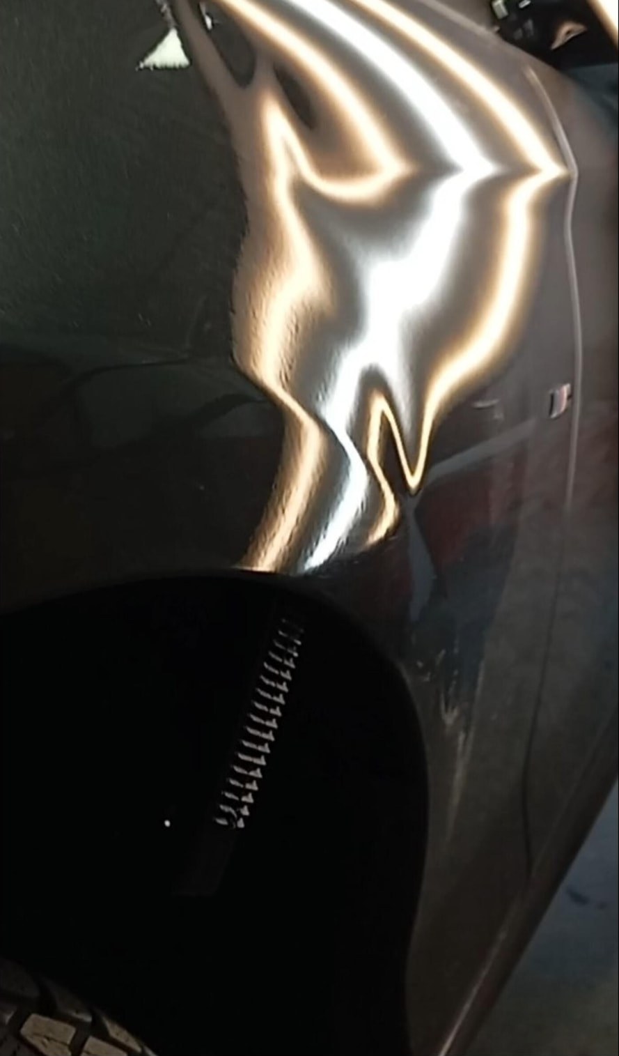 Parafango posteriore BMW grigia con ammaccatura da urto prima del levabolli